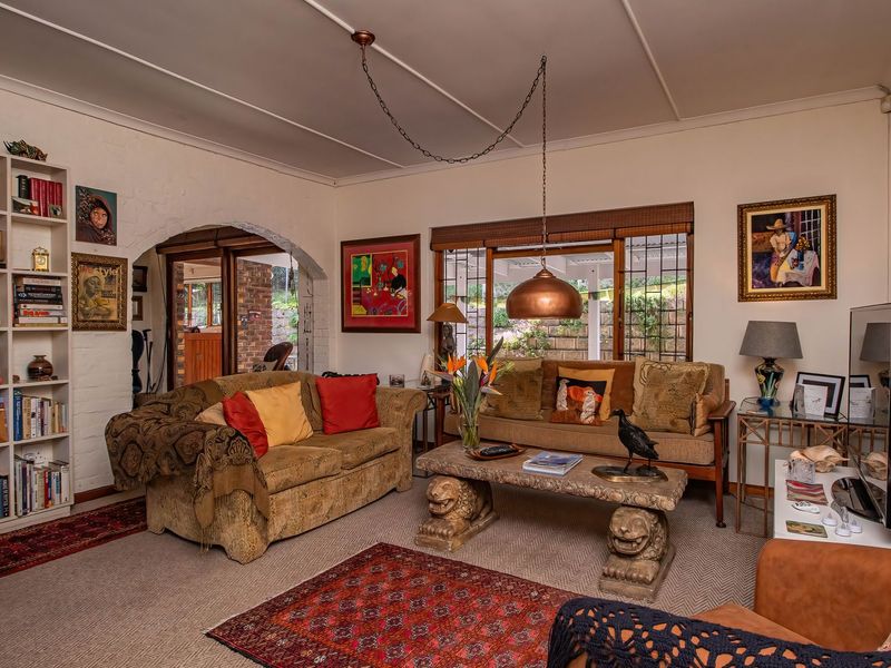 A cozy living room featuring built-in shelving, an arched entryway, and sliding glass doors that provide access to the outdoor patio area.