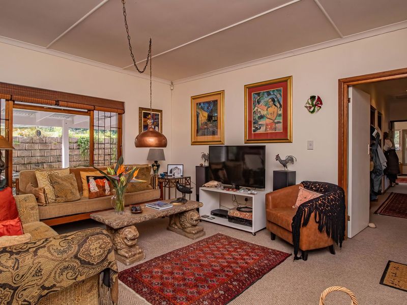 A comfortable living room featuring a large sliding glass door providing access to the outdoor area and classic ceiling detailing.