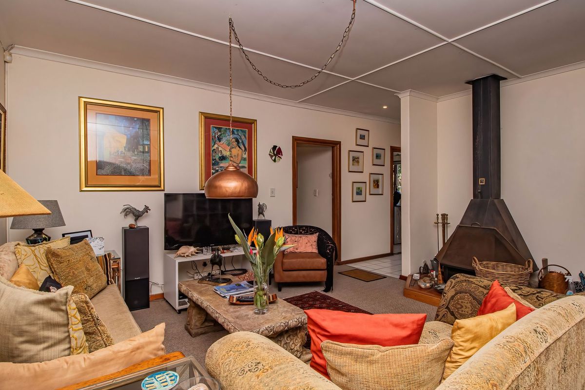 A living room featuring a prominent freestanding fireplace, tiled ceiling, and an arched entryway leading to adjacent spaces.