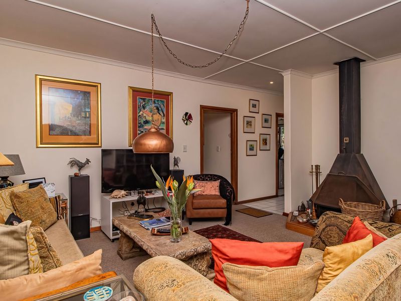 A living room featuring a prominent freestanding fireplace, tiled ceiling, and an arched entryway leading to adjacent spaces.