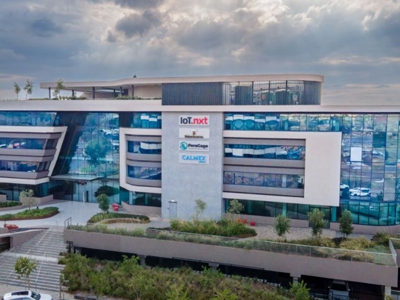 Modern multi-story commercial office building featuring a glass facade, landscaped terraces, and integrated parking facilities.
