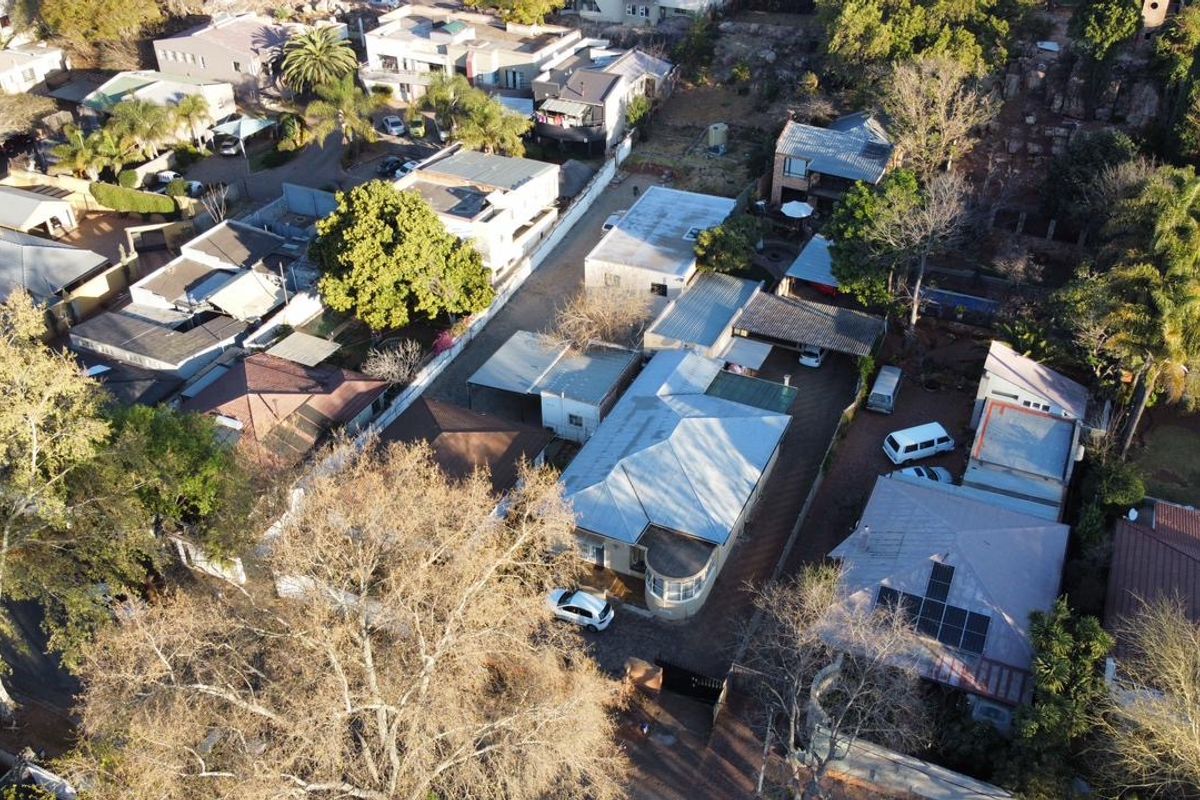 Aerial view of the property showing the main dwelling, metal roofing, solar panel installation, and paved driveway area within the residential neighbourhood.