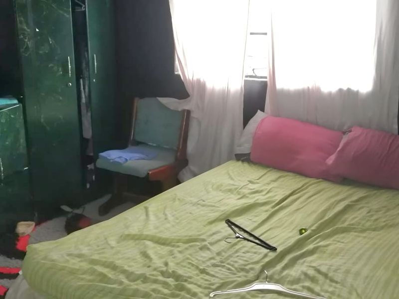A bedroom featuring dark walls and a window with curtains.