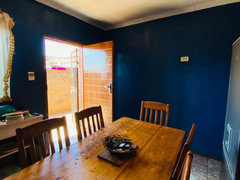 Dining area featuring tiled flooring and direct access to an outdoor space through a solid wood door.