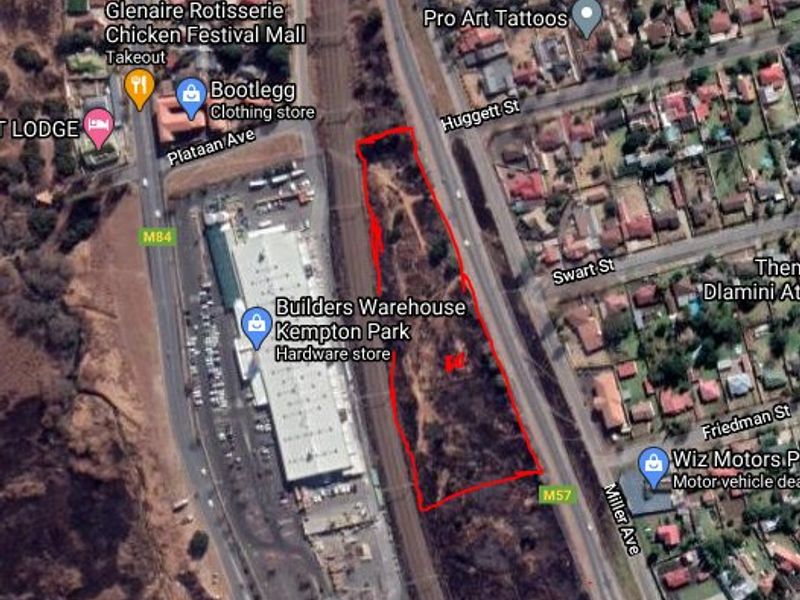 Aerial view of a vacant residential plot situated adjacent to a railway line and commercial infrastructure in Kempton Park.
