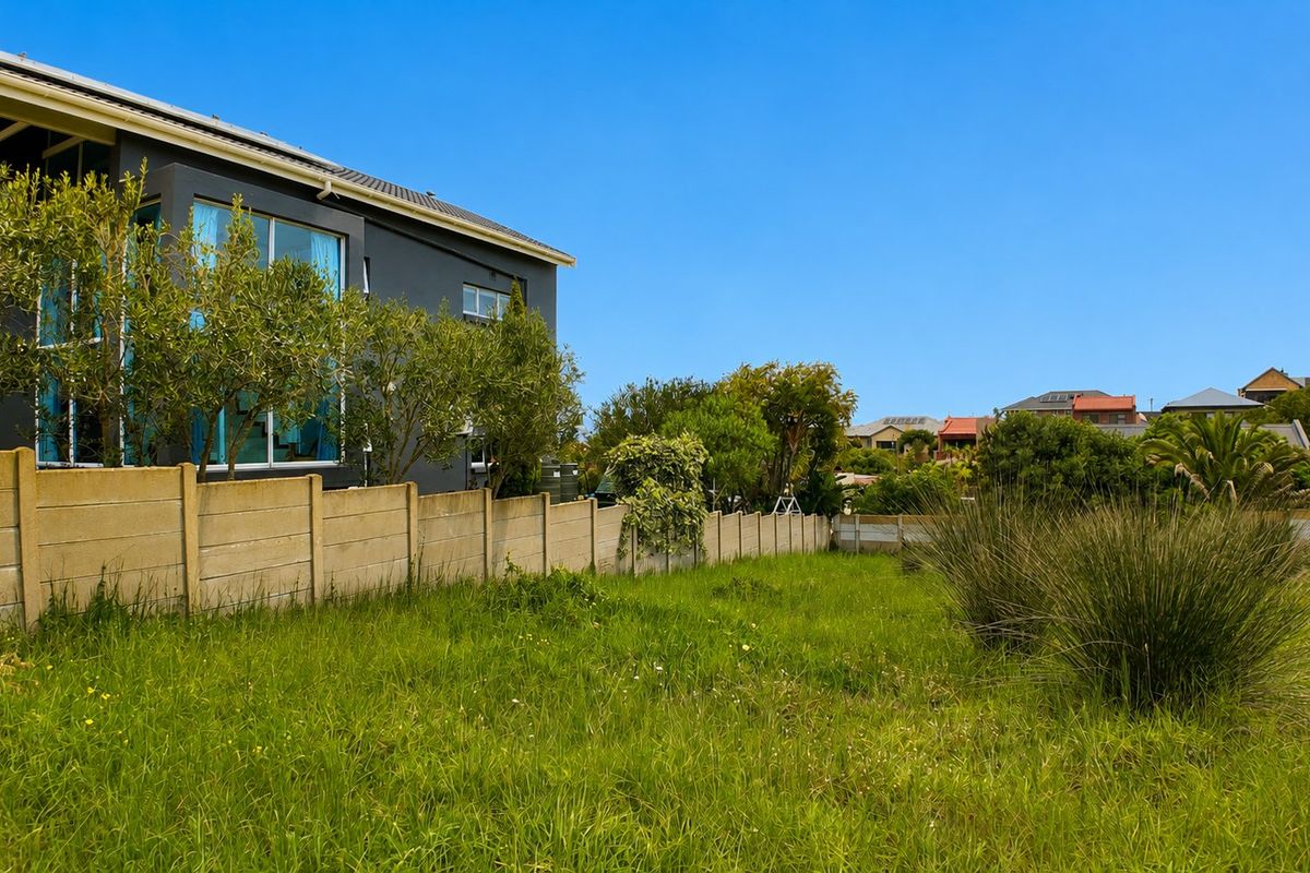 A view of the vacant residential land featuring a precast concrete boundary wall and established grass coverage.
