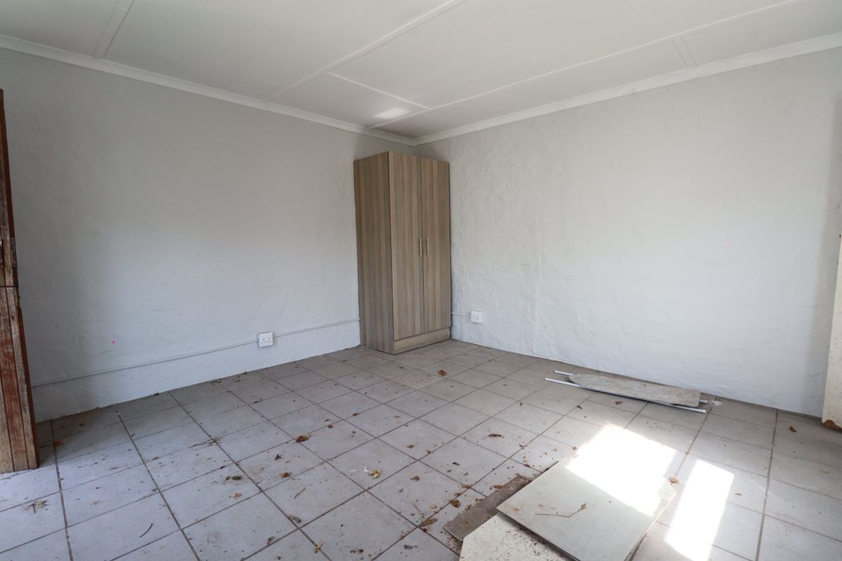 A vacant bedroom featuring tiled flooring and neutral walls, requiring minor repairs and cosmetic updates to enhance its appeal.