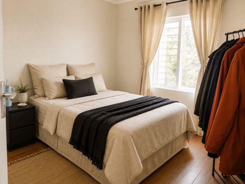 A well-lit bedroom featuring laminate flooring and a window fitted with security bars.