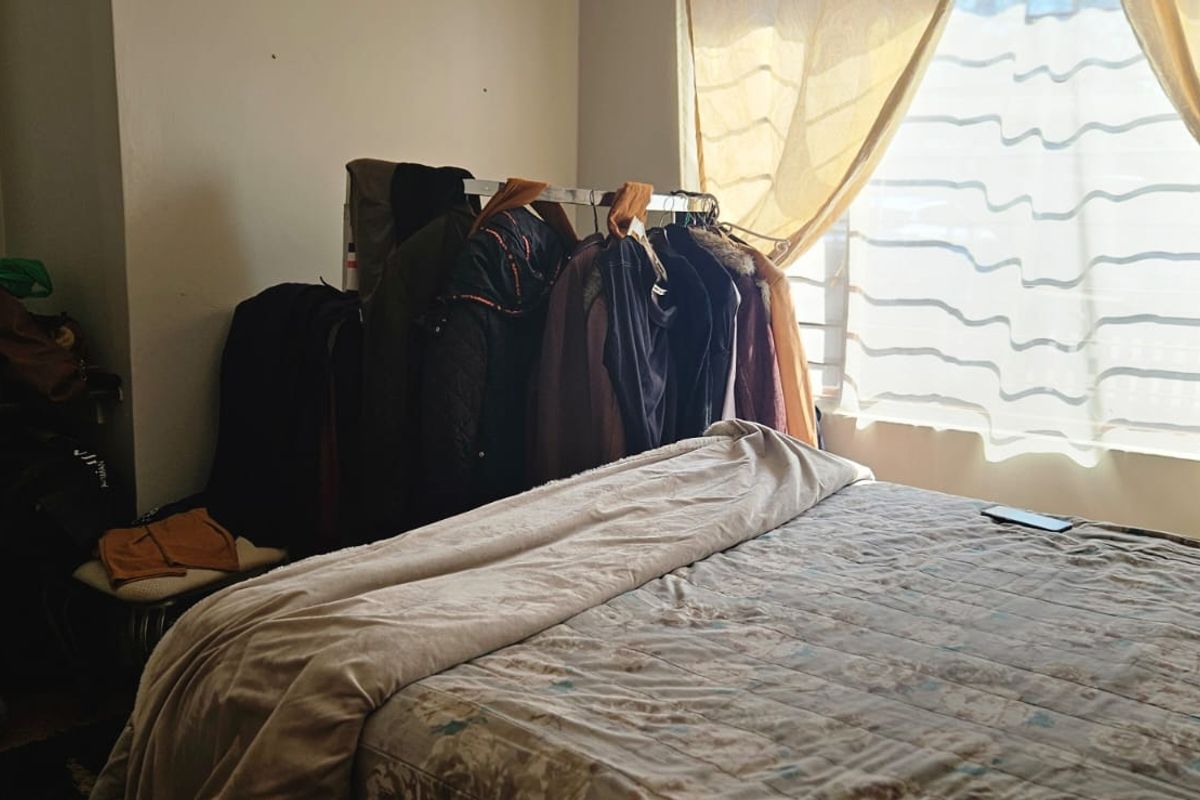 A bedroom featuring a window with natural light and a built-in cupboard, providing a functional space for rest.