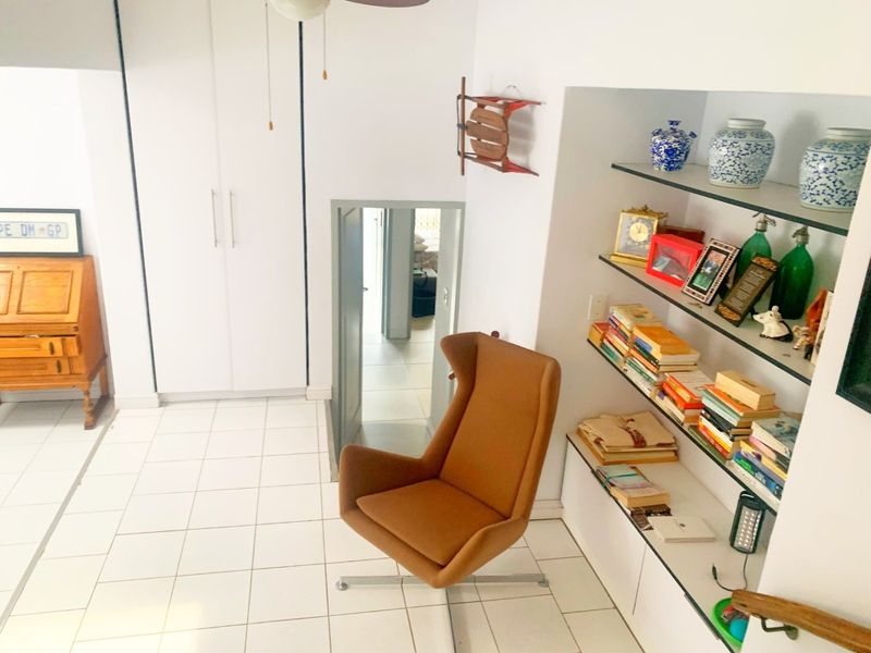 A functional hallway featuring tiled flooring, built-in storage cupboards, and integrated shelving units, providing practical circulation space within the townhouse.