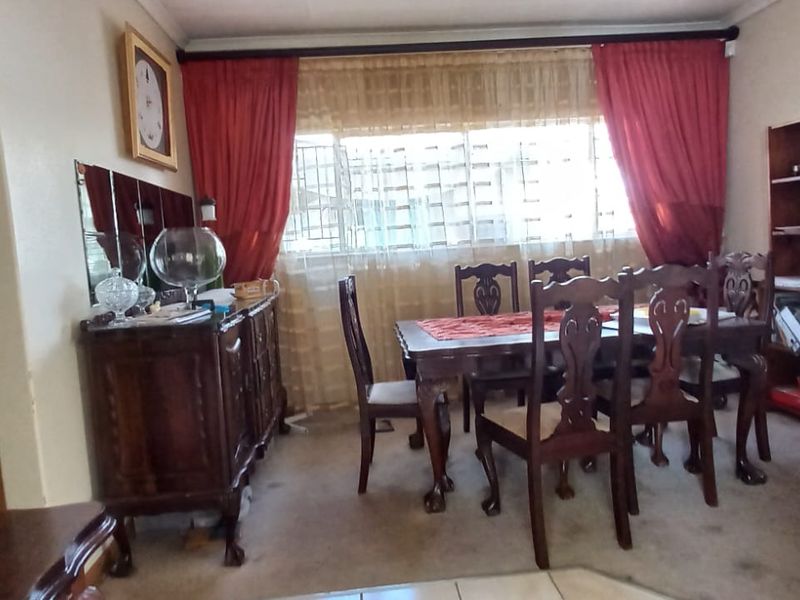 A traditional dining room featuring an arched entryway and built-in shelving, offering a functional space for family meals.