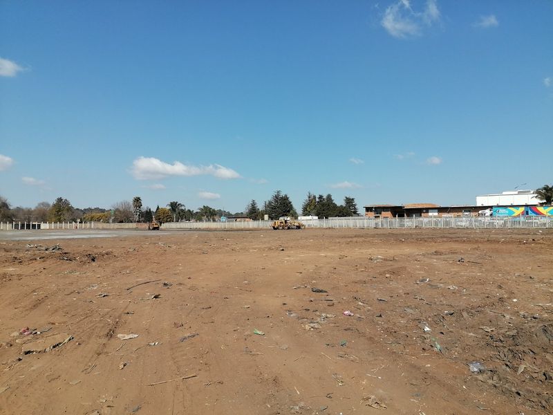 A vacant residential land plot featuring a concrete slab foundation and perimeter fencing, currently undergoing site preparation.
