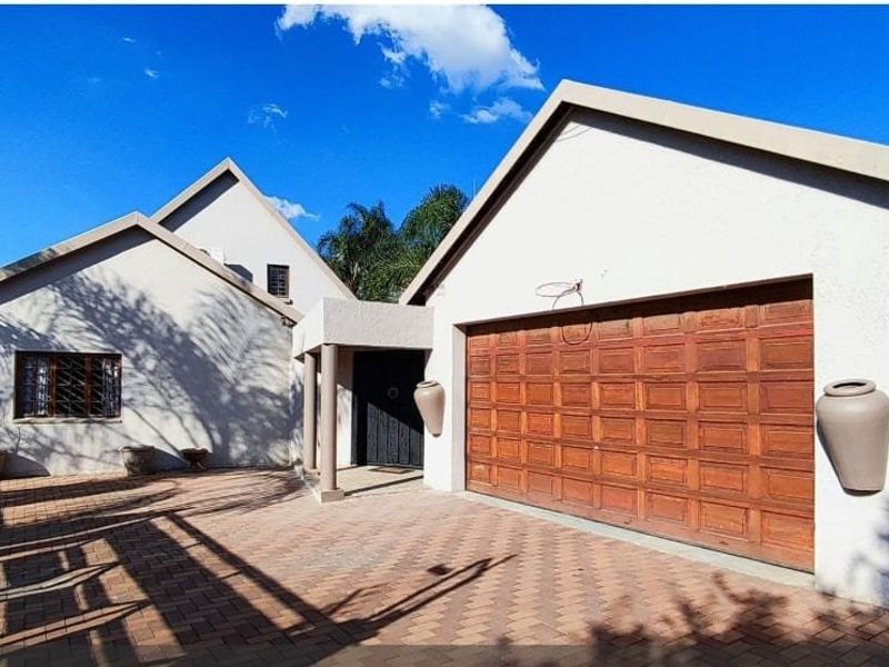 Front elevation of the house featuring a paved driveway, double garage, and covered entrance area.