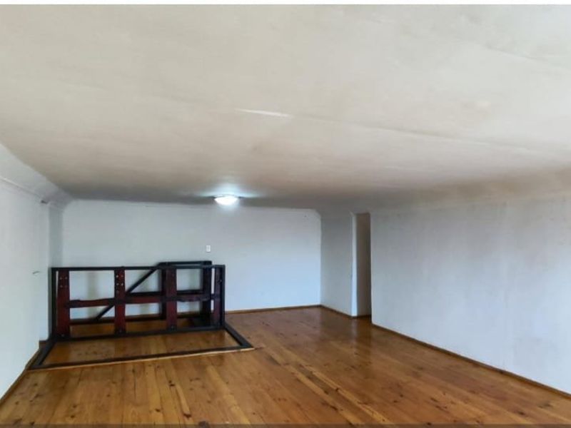 An empty living room featuring polished timber flooring and plain white walls, offering a blank canvas for interior design and personalization.