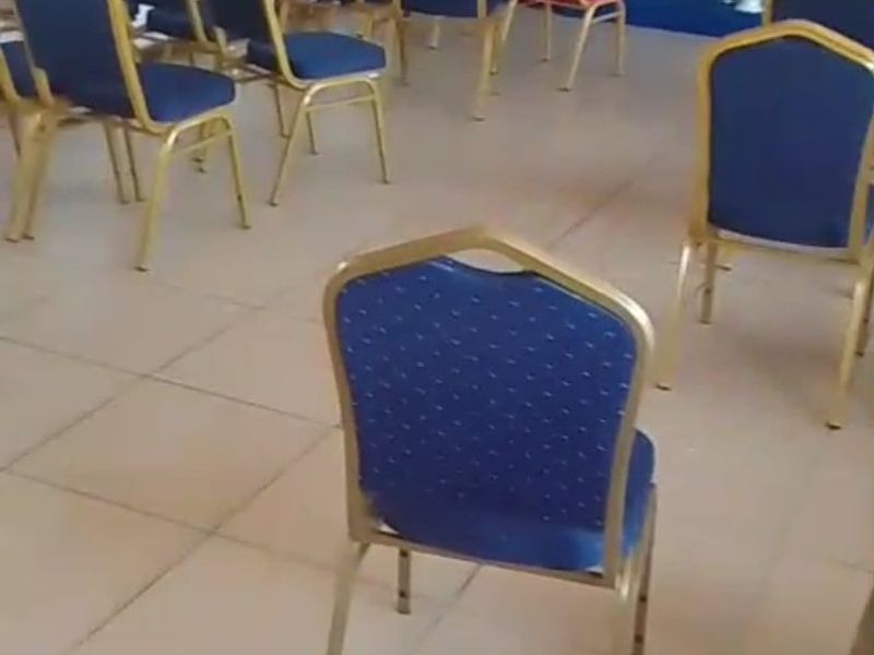A functional commercial event space featuring tiled flooring and a raised stage area, suitable for meetings or presentations.