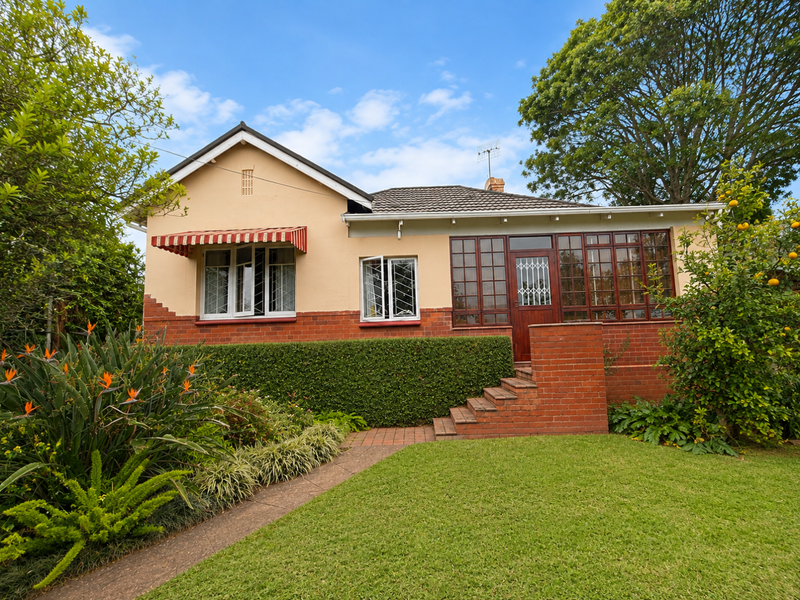 A charming single-story house featuring a classic brick and plaster facade, tiled roof, and a well-maintained front garden with brick steps.