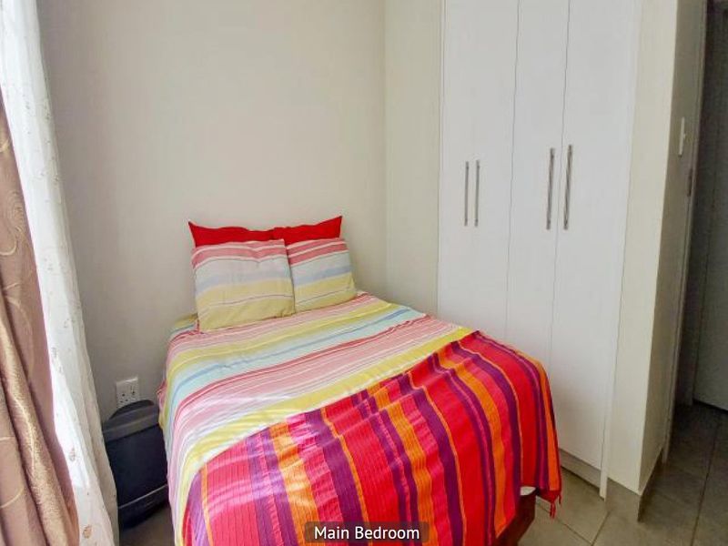 A compact bedroom featuring built-in cupboards and tiled flooring, providing functional storage space.