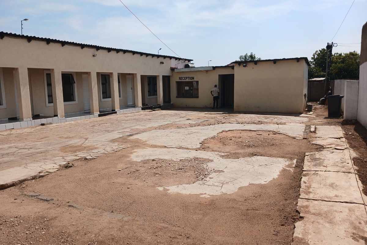 Commercial property courtyard area featuring a reception entrance and covered veranda, currently requiring significant surface repairs and maintenance to the paving.