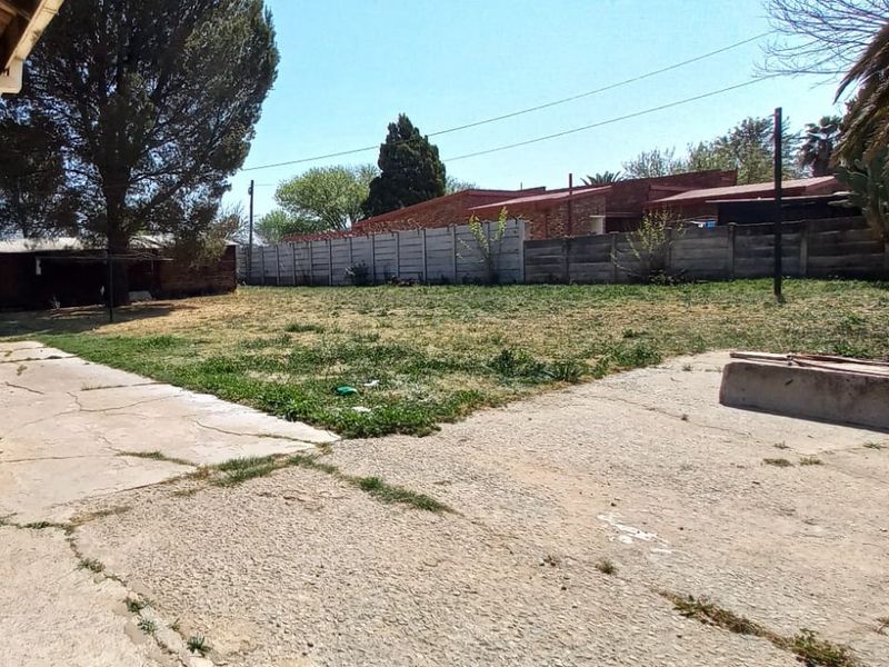 Spacious rear garden featuring a large concrete patio area and precast boundary walling, offering significant potential for landscaping and outdoor entertainment development.