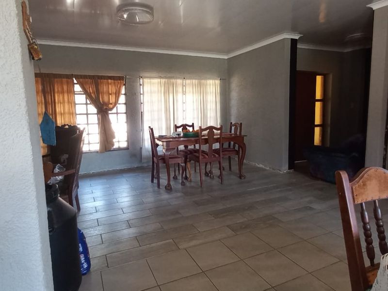 Open plan living and dining area featuring tiled flooring and neutral wall finishes, offering a versatile space for family living.