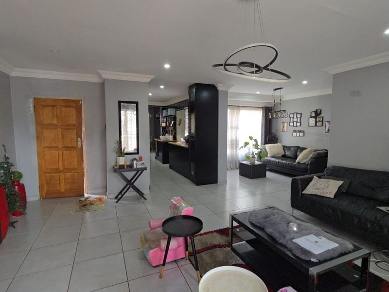 Spacious open-plan living area featuring tiled flooring, recessed lighting, and a seamless flow between the lounge and kitchen space.