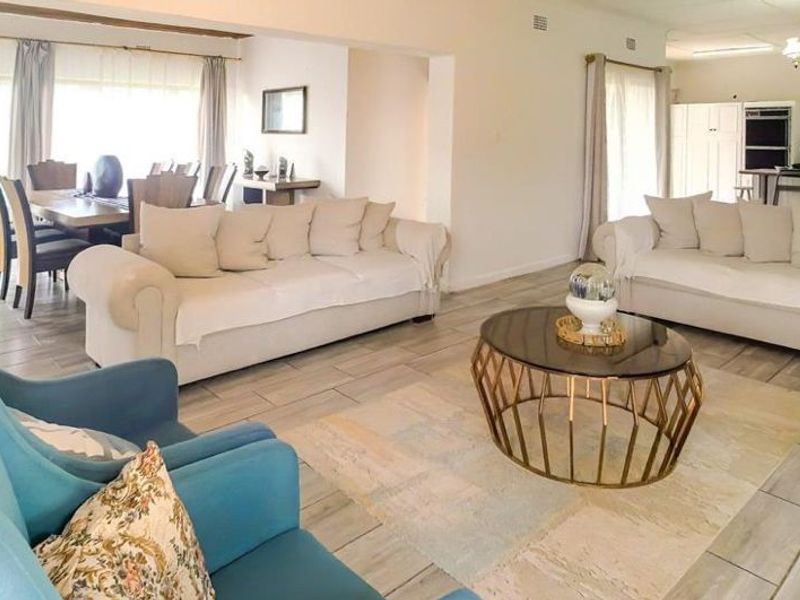 Spacious open-plan living area featuring tiled flooring, integrated kitchen cabinetry, and a seamless flow between the lounge, dining, and kitchen spaces.