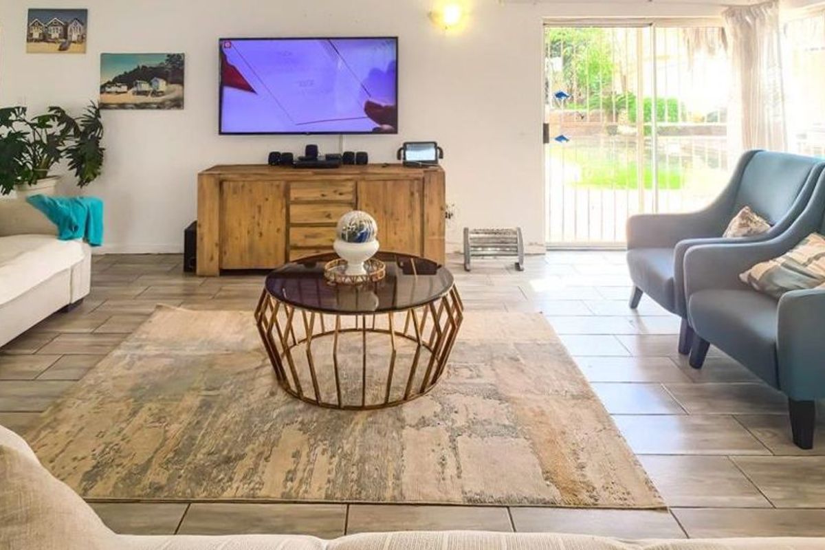 Spacious living room featuring tiled flooring and large sliding glass doors that provide natural light and access to the outdoor area.
