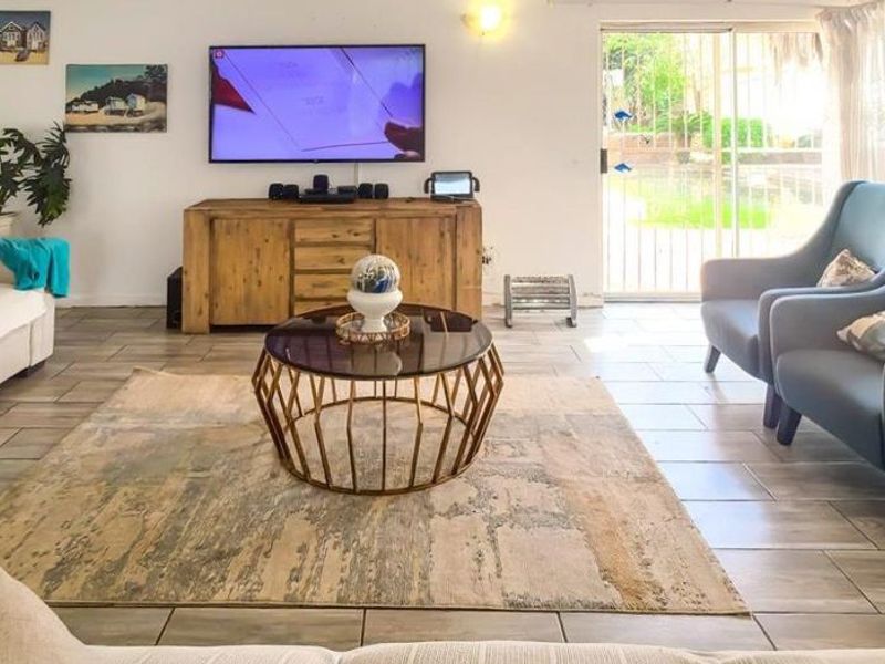 Spacious living room featuring tiled flooring and large sliding glass doors that provide natural light and access to the outdoor area.