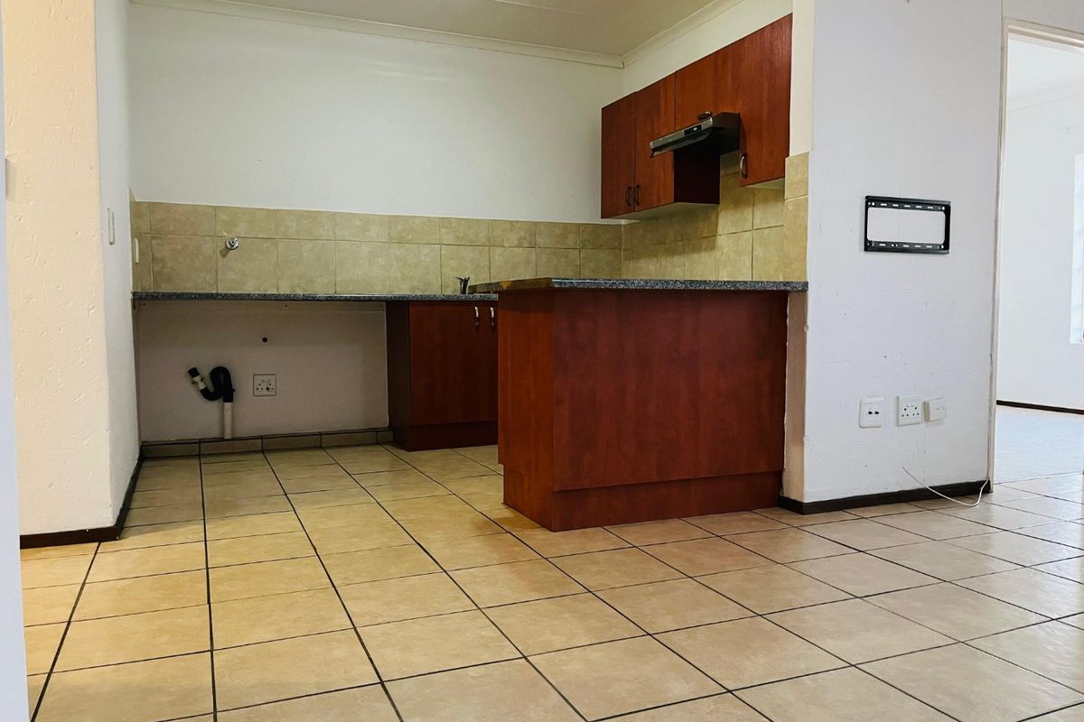 A functional kitchen featuring built-in wooden cabinetry, granite countertops, a tiled backsplash, and dedicated plumbing connections for appliances.
