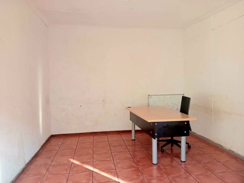 A vacant office space featuring ceramic tile flooring and plain walls, suitable for a professional workspace setup.