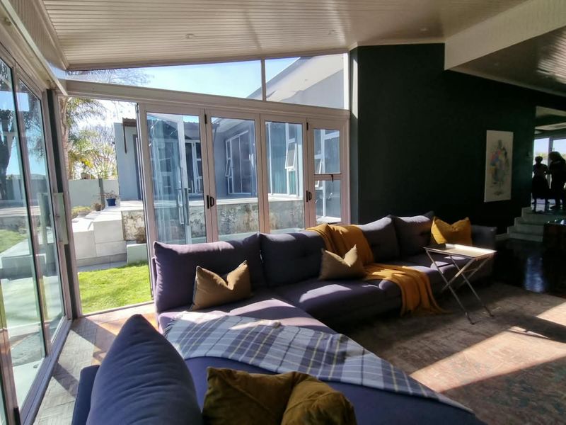 Spacious living room featuring large bi-fold glass doors that provide seamless indoor-outdoor flow to the garden area, complemented by modern ceiling finishes.