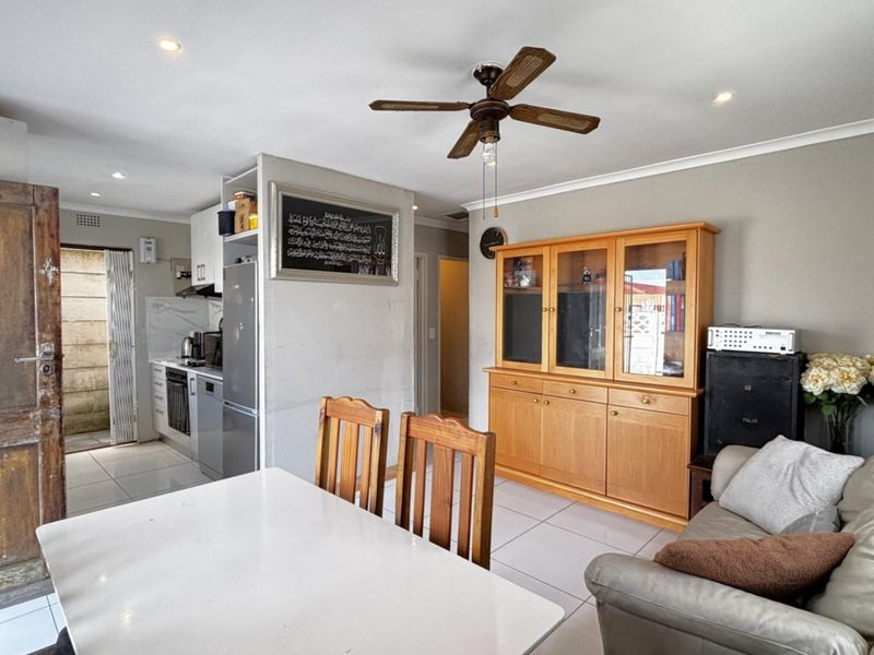 Open-plan living and dining area featuring tiled flooring, recessed lighting, a ceiling fan, and an integrated kitchen space with built-in cabinetry.