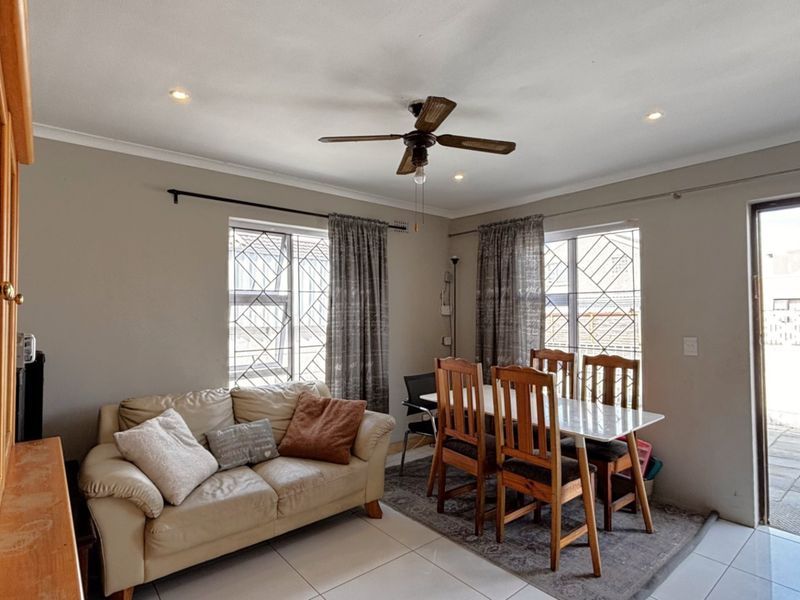Open-plan living and dining area featuring tiled flooring, recessed lighting, a ceiling fan, and direct access to the outdoor patio through a sliding door.