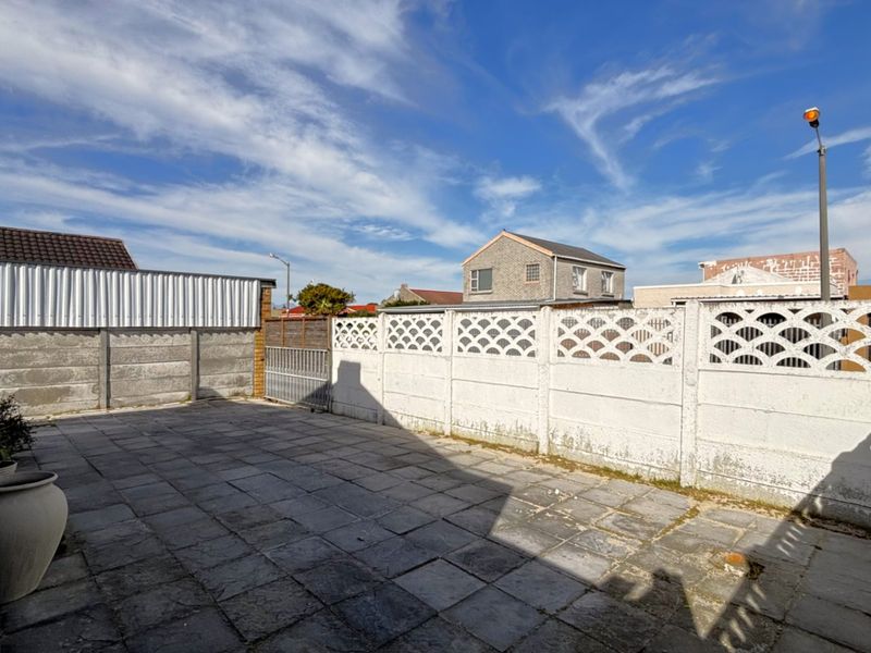 A paved rear courtyard area enclosed by precast concrete boundary walls, offering a private outdoor space.