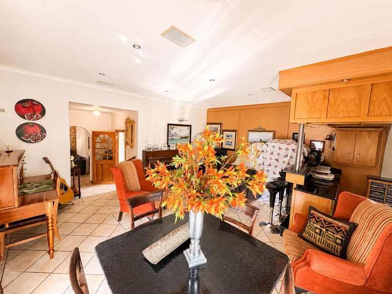 Open plan living and dining area featuring ceramic tiled flooring, built-in cabinetry, and granite countertops, providing a functional and connected living space.