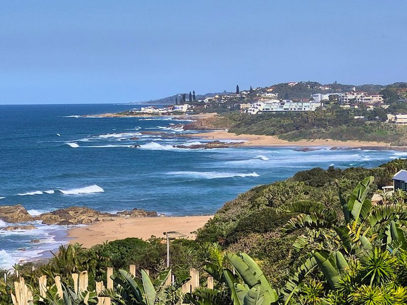 A scenic elevated coastal view overlooking the ocean, sandy beaches, and surrounding residential properties along the coastline.