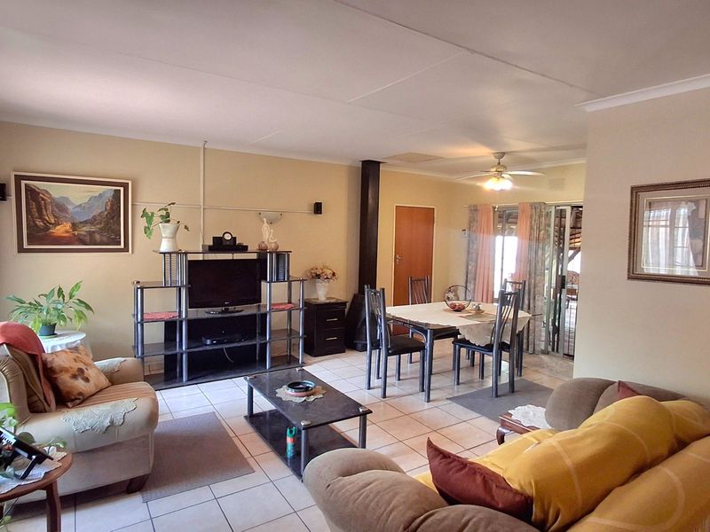 Open-plan living and dining area featuring tiled flooring, a central fireplace, and sliding door access to the outdoor space.