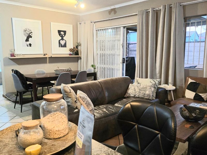Open plan living and dining area featuring tiled floors, a granite kitchen counter, and sliding door access to the outdoor space.