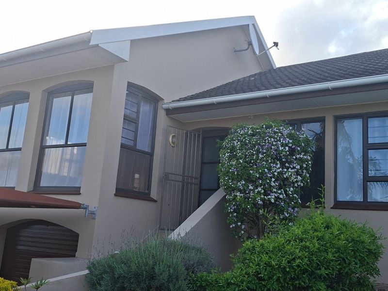 Front elevation of a residential house featuring a tiled roof, aluminium window frames, and integrated garage access.
