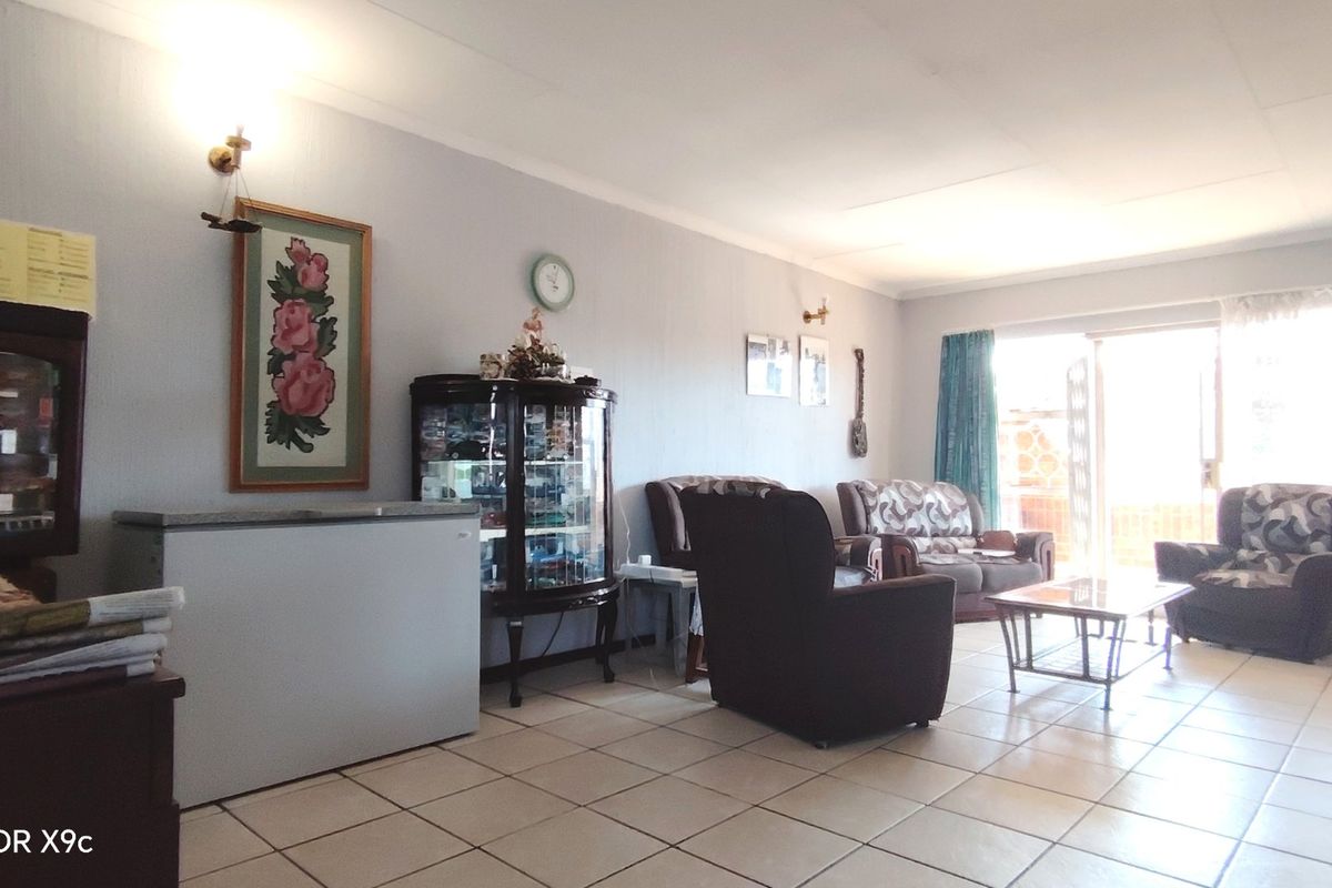 A spacious living area featuring tiled flooring and a sliding glass door providing access to the exterior.