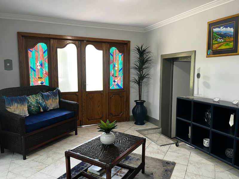 Welcoming entrance area featuring decorative stained glass timber doors, tiled flooring, and convenient elevator access.