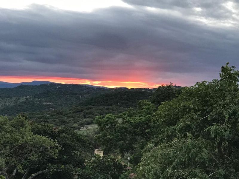A scenic sunset view overlooking the surrounding natural landscape and rolling hills.