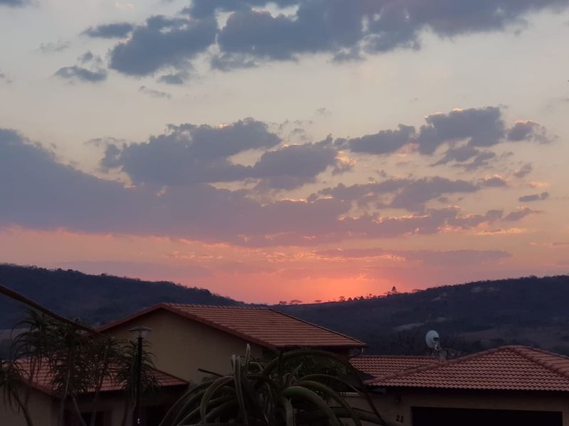 A scenic sunset view overlooking the surrounding hills and residential rooftops.