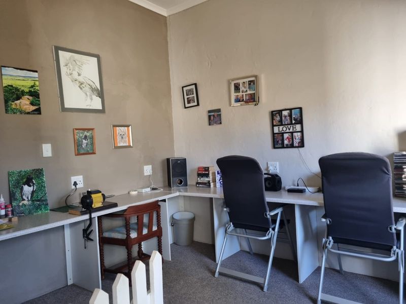 A functional home office space featuring a wrap-around built-in desk with integrated electrical outlets, suitable for a workspace or study area.