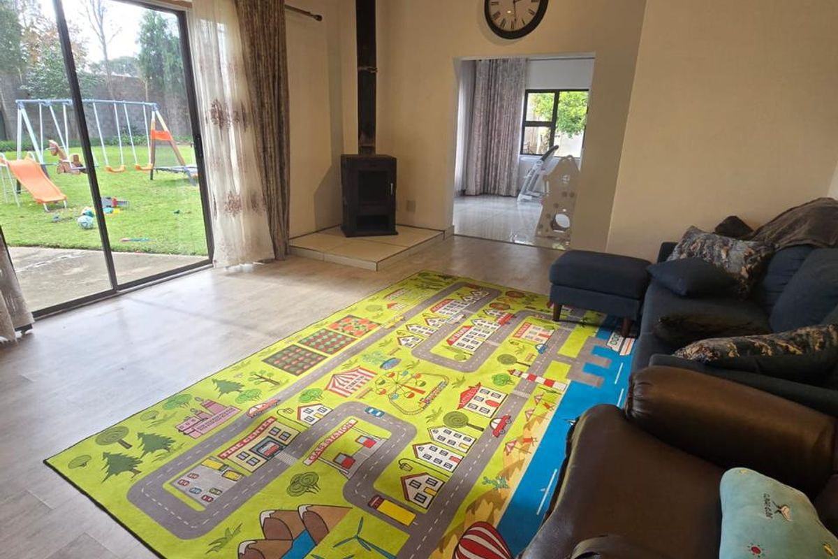 Spacious living room featuring a wood-burning stove, timber-clad ceiling, and large sliding glass doors providing direct access to the rear garden.