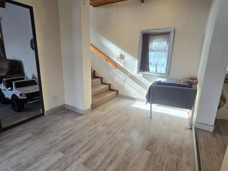 Entrance hall featuring timber ceiling, recessed lighting, and staircase with timber handrail, finished with modern laminate flooring.