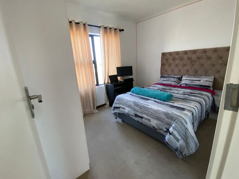 A functional bedroom featuring carpeted flooring and a window, providing a comfortable space for rest.
