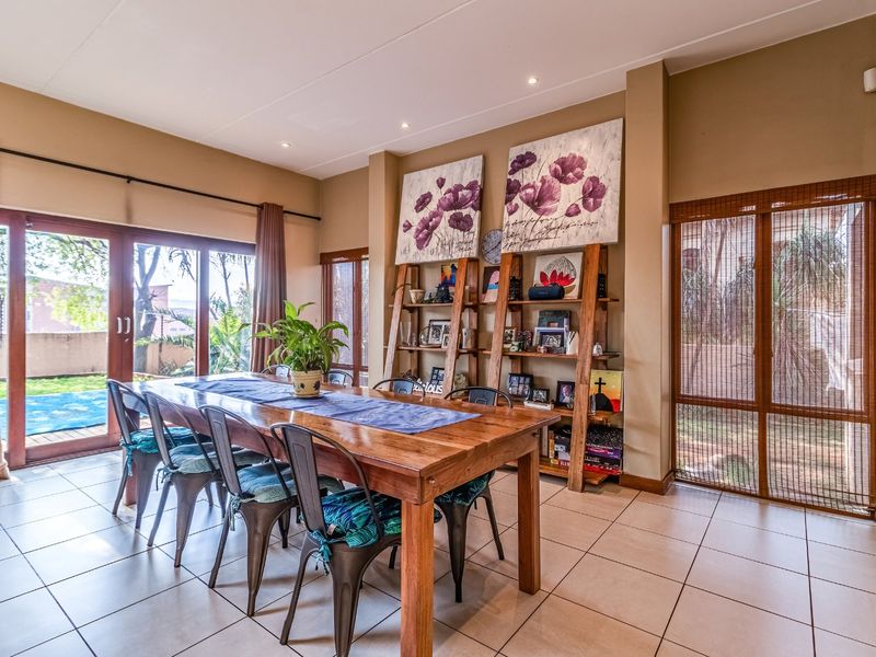 A bright dining room featuring tiled flooring, recessed lighting, and large sliding glass doors that provide direct access to the outdoor area.