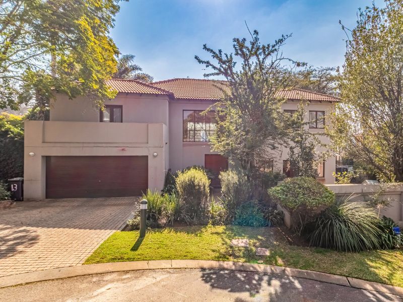 A well-maintained double-story residential property featuring a tiled roof, paved driveway, and an integrated double garage with a landscaped front garden.