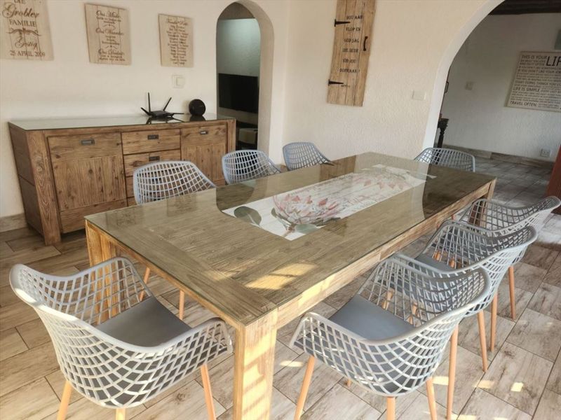 A dining room featuring tiled flooring and distinctive arched doorways, providing an open and connected feel to the adjacent living spaces.